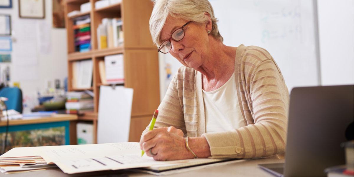 Senior student writing at desk